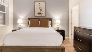 a bedroom with a large white bed with two lamps at Landing Stylish 2BD Gym Pool in Colorado Springs +62 photos