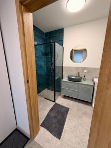 a bathroom with a glass shower and a sink at Apartament Tarasy Wenecji 2 in Gniezno +42 photos