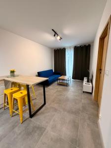 a living room with a table and a blue couch at Apartament Tarasy Wenecji 2 in Gniezno