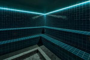 a blue tiled bathroom with a tub with blue lights at Hotel Laudinella in St. Moritz +54 photos