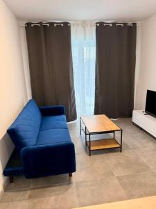 a living room with a blue couch and a coffee table at Apartament Tarasy Wenecji 2 in Gniezno