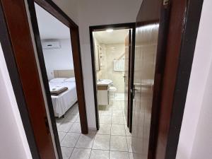 a room with a bathroom with a bed and a mirror at Apartamentos Nadai 201 in Foz do Iguaçu +35 photos