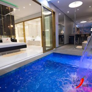 a bathroom with a swimming pool with a water slide at Motel Você Que Sabe Temático Deluxe in Cacoal