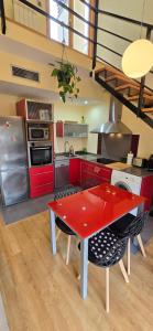 a kitchen with red cabinets and a red table at Mirador del Torreón in Alcañiz