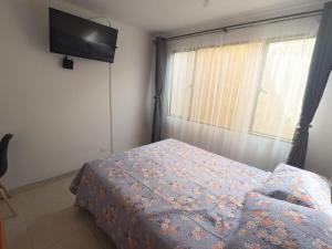 a bedroom with a bed and a flat screen tv at Bacata Housing full in Bogotá
