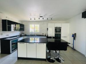 a kitchen with white cabinets and black counter tops at Vila paradise in Ollioules +4 photos