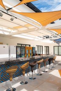 a bar with brown stools in a building at Villa Santorini Boutique & Hotel in Pirenópolis +99 photos