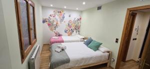 two beds in a room with a mural on the wall at Mirador del Torreón in Alcañiz +26 photos