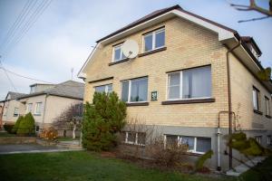 a house with a clock on the side of it at Azimut Guest House Self Check-in in Šiauliai