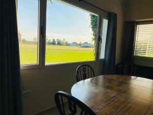 a dining room with a table and a large window at Las Agujas in Aldea Camarero