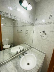 a bathroom with a sink and a toilet and a mirror at Las Agujas in Aldea Camarero +21 photos