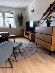 a living room with a tv and a dresser at Apartment 18 in Kurort Oberwiesenthal