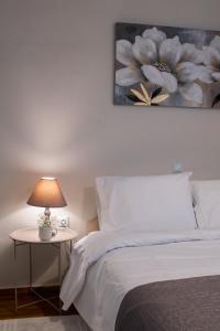 a bedroom with a bed and a table with a lamp at Lithaia Aura-Trikala in Pýrgos
