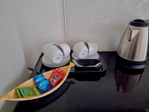 a counter top with a coffee pot and a plate of food at Kandy Rainbow Villa in Kandy