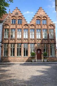 an old brick building with windows and a door at Experiencebruges in Bruges