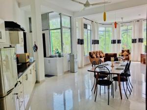 a kitchen and living room with a table and chairs at Kandy Rainbow Villa in Kandy