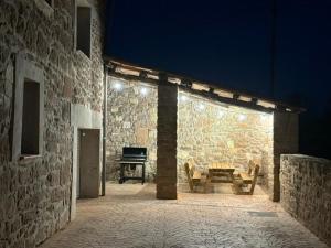 a stone building with a bench and a piano at Cal Perico in San Pedro Sallavinera