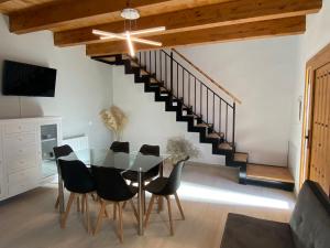 a dining room with a glass table and black chairs at Cal Perico in San Pedro Sallavinera