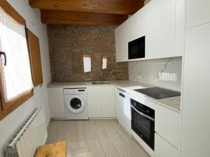 a kitchen with a washing machine and a washer and dryer at Cal Perico in San Pedro Sallavinera +8 photos