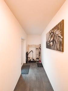 a hallway with a painting of a horse on the wall at Dalila Appartements in Sankt Michael im Lungau