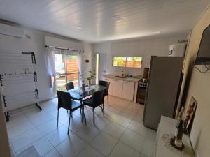 a kitchen with a table and chairs and a refrigerator at Bajo el Sauce in Ranchos