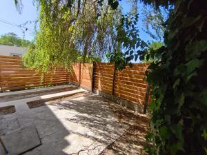a brick fence with a tree in front of it at Bajo el Sauce in Ranchos