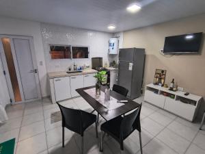 a kitchen with a table with chairs and a refrigerator at Bajo el Sauce in Ranchos