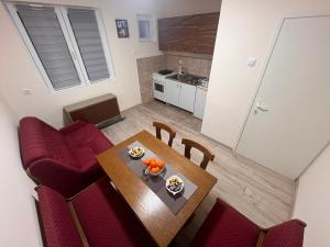 a kitchen and dining room with a table and red chairs at Apartman Tas in Smederevo +10 photos