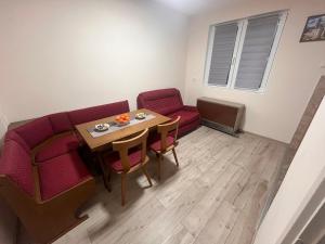 a living room with a couch and a table and chairs at Apartman Tas in Smederevo