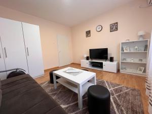 a living room with a couch and a table and a tv at Apartman Tas in Smederevo