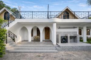 a white house with a staircase leading up to it at Toiwo Residence 4BR Home in Ilboru, Arusha in Arusha