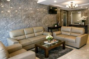 a living room with couches and a table at Hotel Sakura Inn in Hosūr
