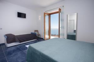 a bedroom with a bed and a view of the ocean at Nel blu dipinto di blu in Pianillo