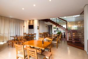 a restaurant with wooden tables and chairs and a staircase at Pousada Viver Capitólio in Capitólio +54 photos