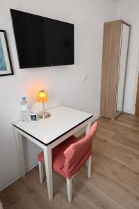 a white table with a lamp and a chair at Hotel Haus Schwan Köln in Cologne +43 photos