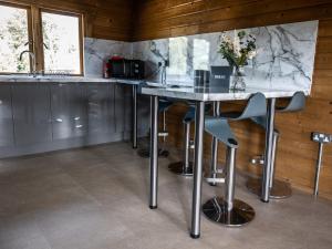 a kitchen with a marble counter top and stools at Buzzards Retreat in Larling