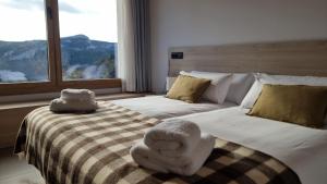 a bedroom with a large bed with towels on it at Cal Rocamartí, Turisme Rural - Montant de Tost, Pirineu in Montant