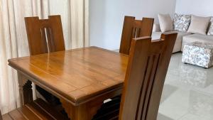 a wooden table and chairs in a living room at Opal Heights in Gampaha +12 photos