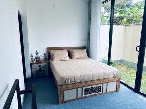 a bed in a room with a large window at Sea esta villa in Mount Lavinia