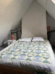 a bedroom with a bed with a quilt on it at La Maison du Patou in Cadéac