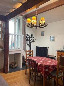 a dining room with a table and a chandelier at La Maison du Patou in Cadéac