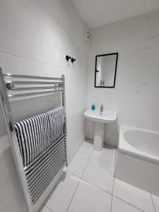 a white bathroom with a shower and a sink at Quayside Waters in Dundee +16 photos