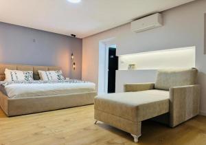 a bedroom with a bed and a couch and a chair at Lapi Guest House Korca in Korçë