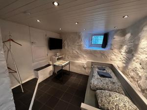a room with a tub and a television in it at Cozy apartment in quiet neighborhood in Oslo