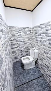 a bathroom with a toilet in a brick wall at Sunset Villa in Hambantota
