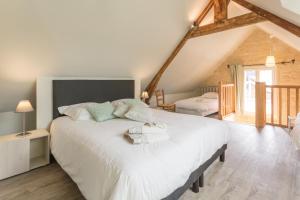 a bedroom with a large white bed in a attic at Le Relais des Flâneurs in Thaon