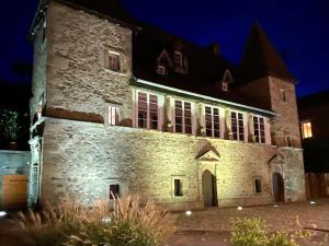 an old stone building at night with lights on at Gîte des Templiers in Couches