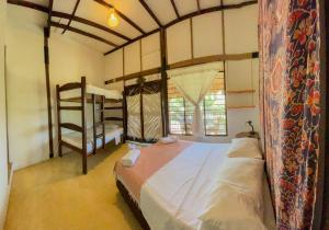 a bedroom with a bed and a bunk bed at Hostal El Bohío in Palomino