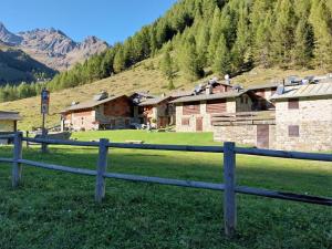 a wooden fence in front of a field with houses at Bella Vista casa vacanze in Grosio