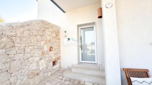 a door to a building with a stone wall at AQUARAMA Rooms & Apartments in Torre Squillace +12 photos